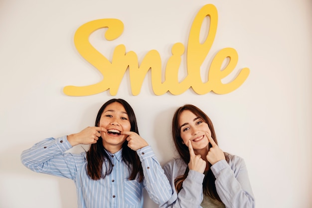 Foto gratuita dos mujeres mostrando sonrisas