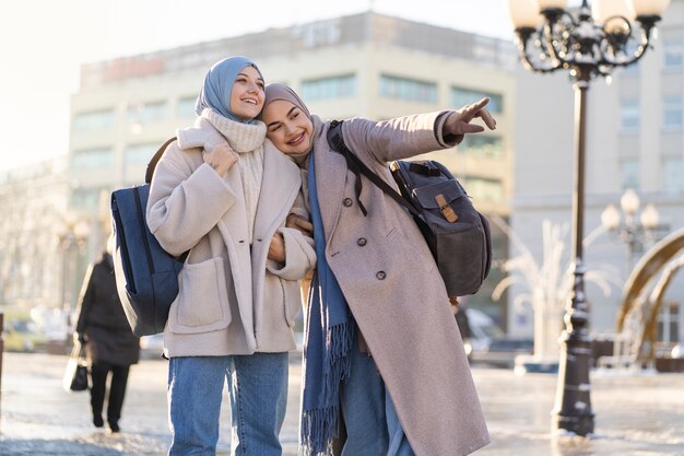 Dos mujeres musulmanas mirando alrededor de la ciudad mientras viajan