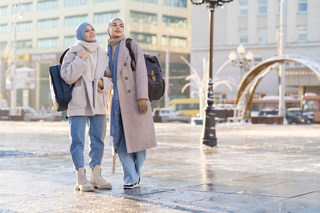 Dos mujeres musulmanas mirando alrededor de la ciudad mientras viajan