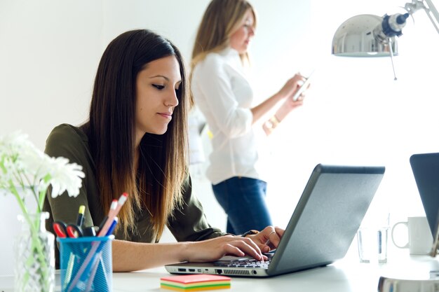 Dos mujeres de negocios que trabajan en su oficina.