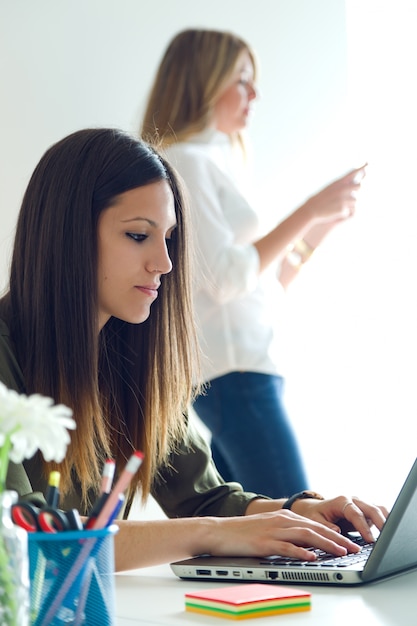 Dos mujeres de negocios que trabajan en su oficina.