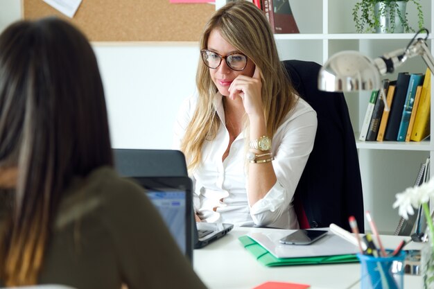 Dos mujeres de negocios que trabajan en su oficina.