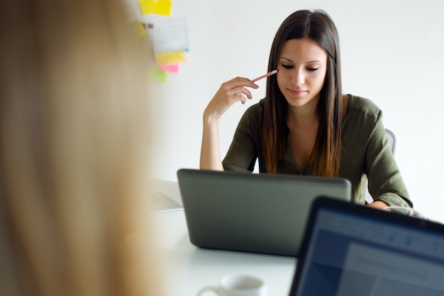 Dos mujeres de negocios que trabajan en su oficina.