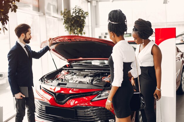 Dos mujeres negras con estilo en un salón de autos