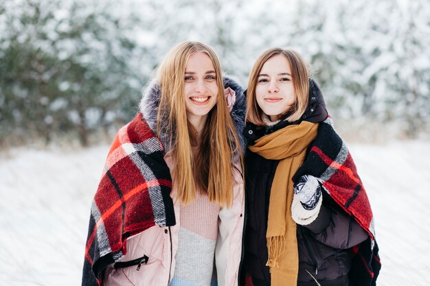 Dos mujeres de pie en el bosque de invierno