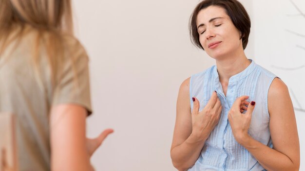 Dos mujeres que usan lenguaje de señas para hablar entre sí