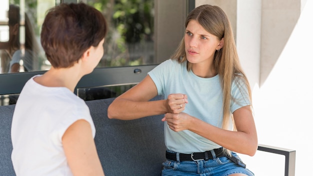 Dos mujeres que utilizan el lenguaje de señas para comunicarse entre sí