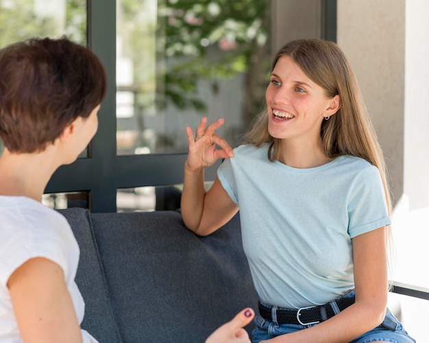 Dos mujeres que utilizan el lenguaje de señas para conversar entre sí