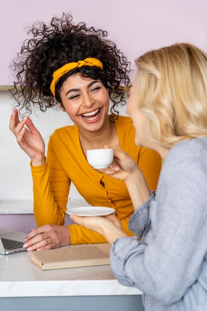 Foto gratuita dos mujeres, reír, mientras, tomar café