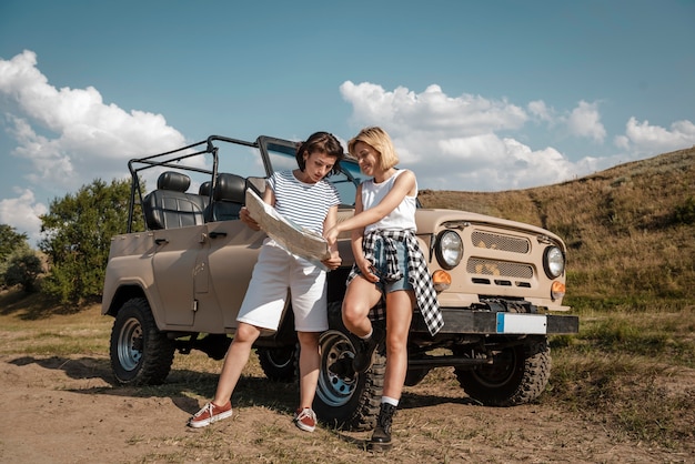 Dos mujeres revisando el mapa juntos mientras viaja en coche