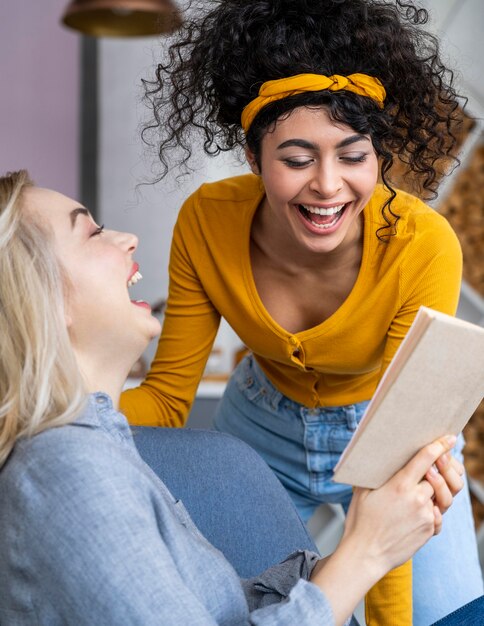 Dos mujeres riendo mientras lee el libro