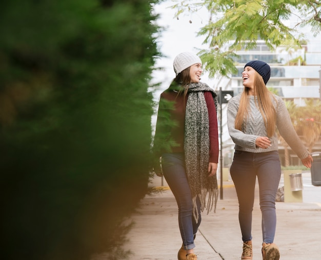 Dos mujeres sonrientes caminando en el parque