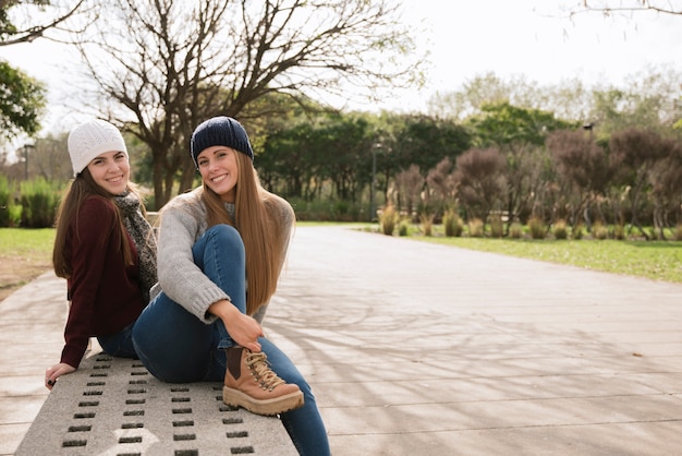 Foto gratuita dos mujeres sonrientes sentadas en un banco