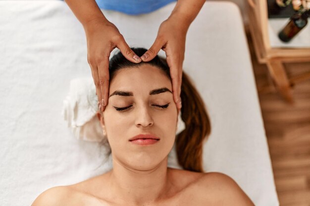 Dos mujeres terapeuta y paciente con sesión de masaje facial en el centro de belleza