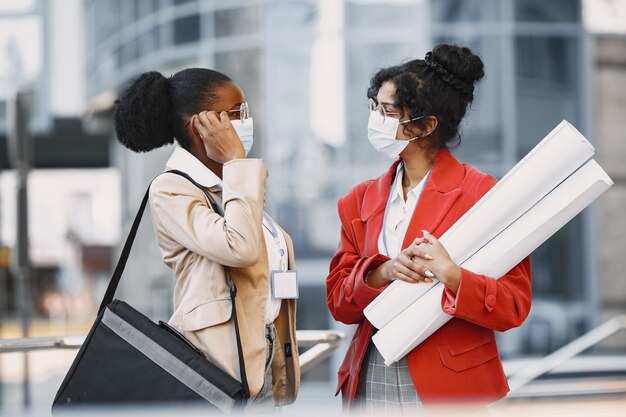 Dos mujeres trabajando como arquitectas en una restricción. Personas que toman una decisión sobre el plan de un edificio. Concepto de cuarentena