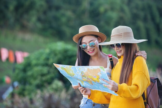 Dos mujeres turistas sostienen un mapa para encontrar lugares.