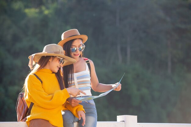 Dos mujeres turistas sostienen un mapa para encontrar lugares.