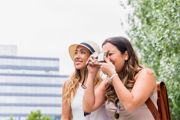 Foto gratuita dos mujeres viajeras tomando fotografía de cámara