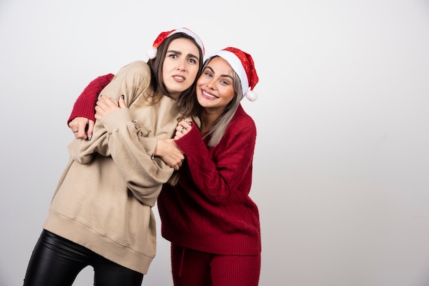 Dos niñas asustadas vestidas con suéteres calientes posando