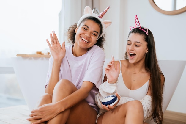 Dos niñas en el baño jugando con crema para la cara