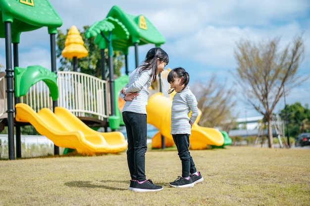 Foto gratuita dos niñas jugando felizmente en el patio de recreo
