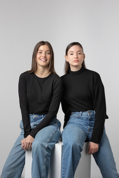 dos niñas, llevando, negro, camiseta, posar, en, estudio