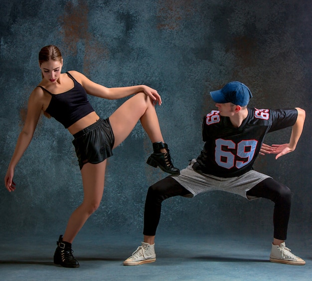 Las dos niñas y un niño bailando hip hop en el azul