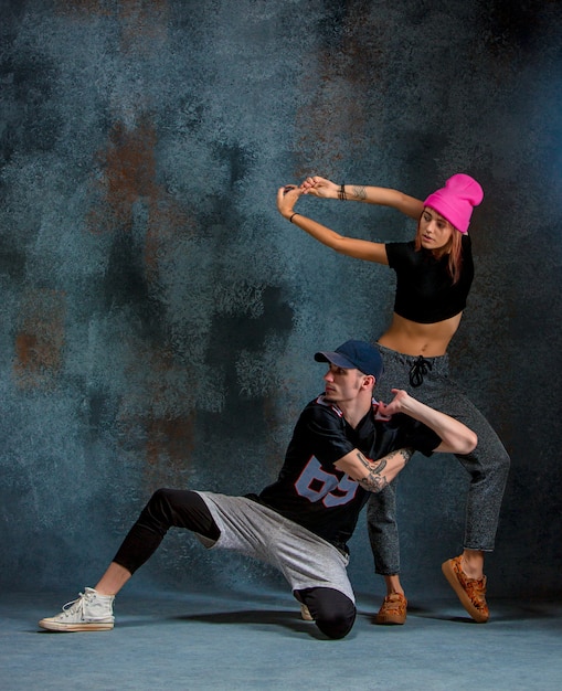 Las dos niñas y un niño bailando hip hop en el estudio