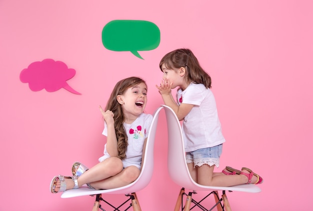 Dos niñas en la pared de color con iconos de voz