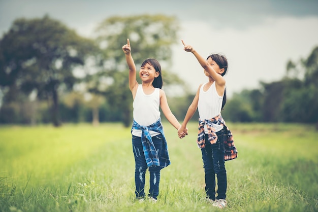 Dos niñas sosteniendo juntos divirtiéndose en el parque