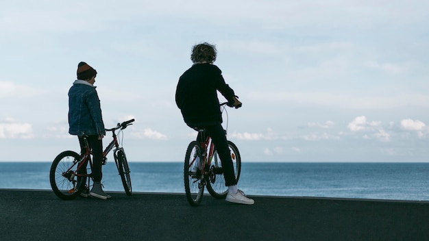 Dos niños al aire libre en la ciudad con sus bicicletas y espacio de copia