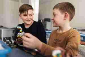 Foto gratuita dos niños construyendo un robot con componentes electrónicos