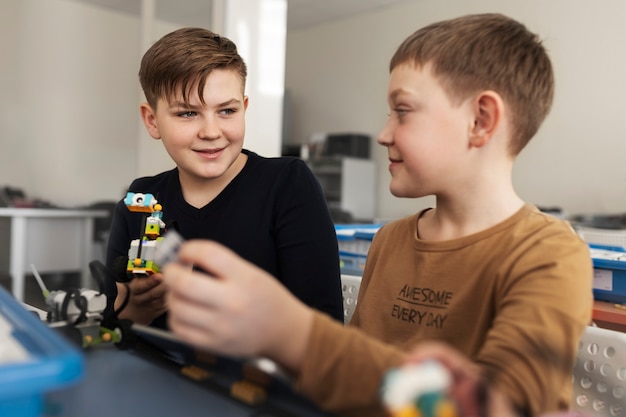 Dos niños construyendo un robot con componentes electrónicos