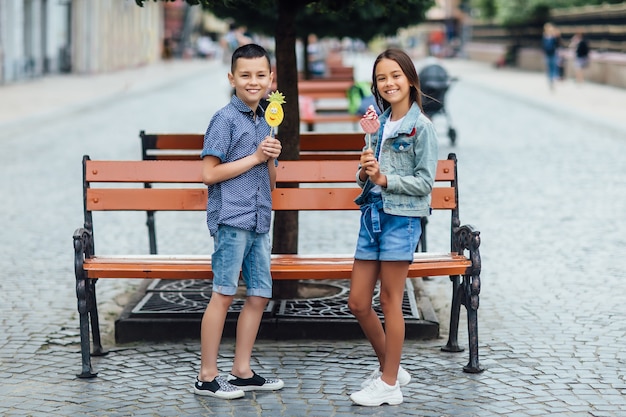 Dos niños felices un día de verano con dulces en las manos y sonriendo.