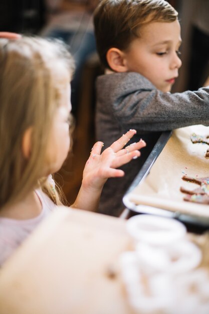 Dos niños haciendo pan de jengibre