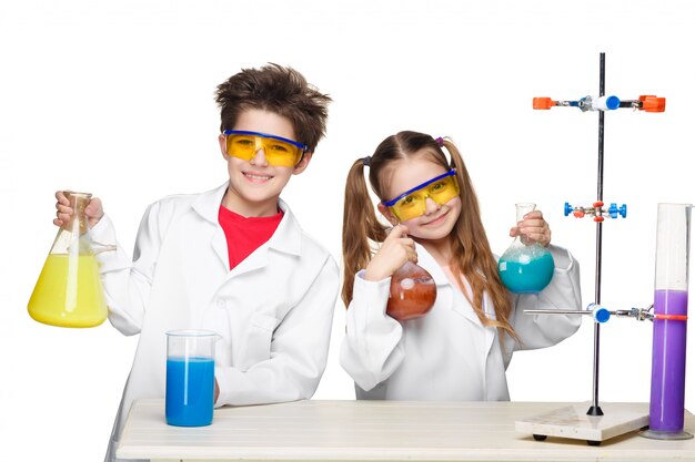 Dos niños lindos en la lección de química haciendo experimentos