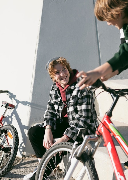 Foto gratuita dos niños en el parque divirtiéndose con sus bicicletas.