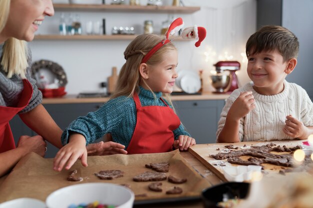 Dos niños y su madre cortando galletas de jengibre