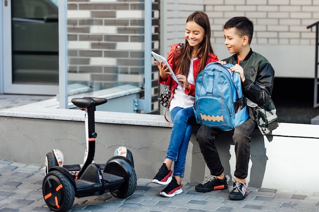 Dos niños van a la escuela para gyroscooters.