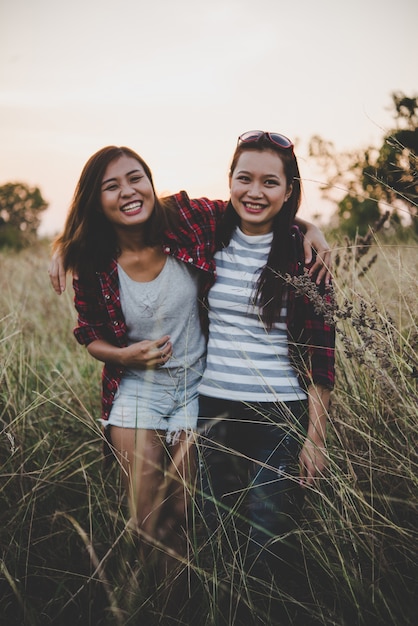 Foto gratuita dos novias adolescentes inconformista que se divierten en el campo. las mujeres concepto de estilo de vida.