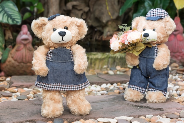 Dos osos de peluche sobre fondo de jardín