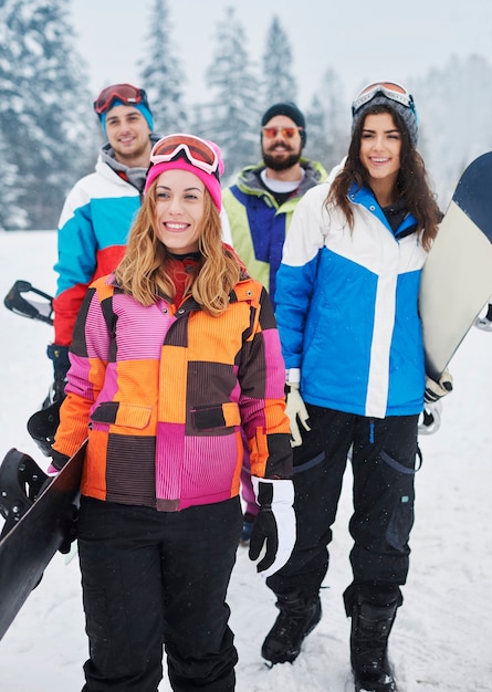 Dos parejas divirtiéndose y haciendo snowboard.