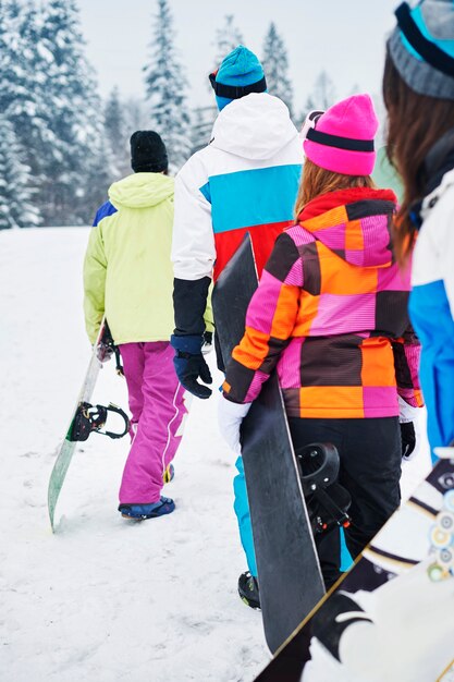 Dos parejas divirtiéndose y haciendo snowboard.