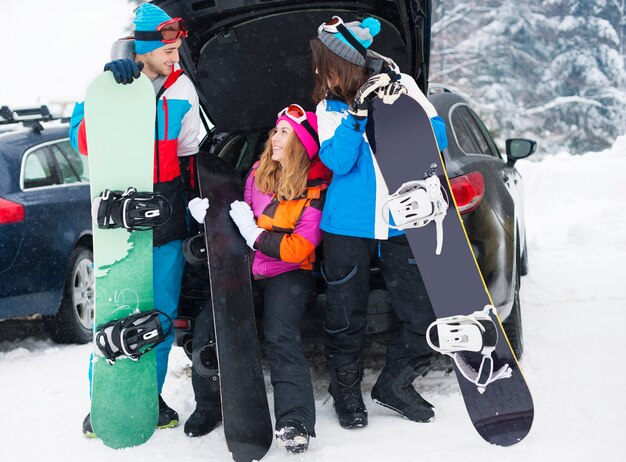 Dos parejas divirtiéndose y haciendo snowboard.