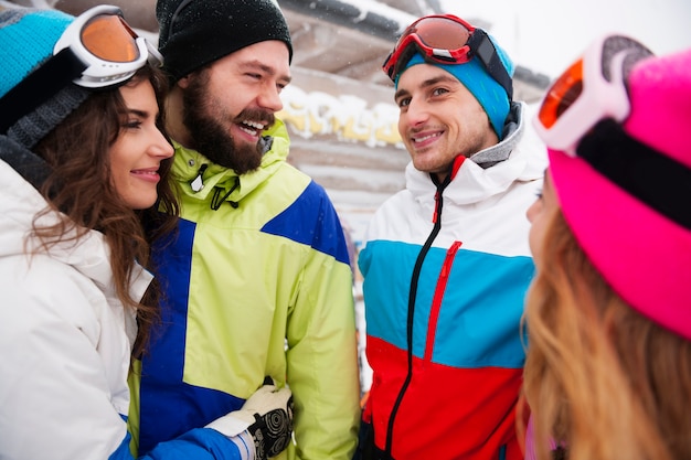 Dos parejas divirtiéndose y haciendo snowboard.