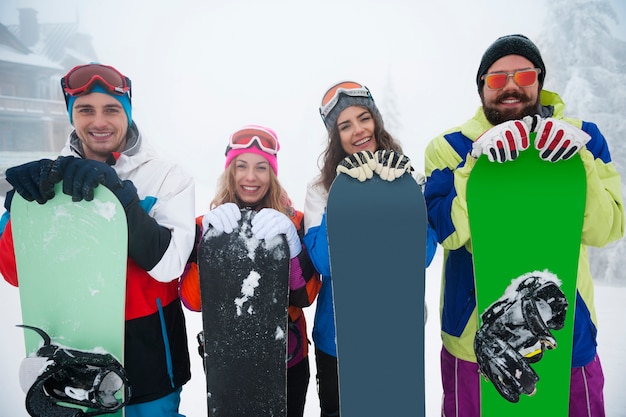 Dos parejas divirtiéndose y haciendo snowboard.