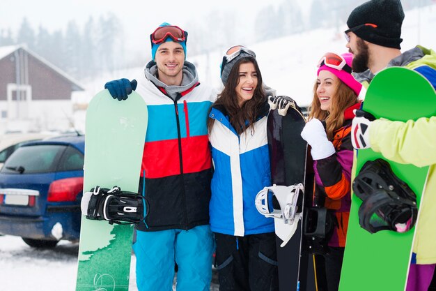 Dos parejas divirtiéndose y haciendo snowboard.