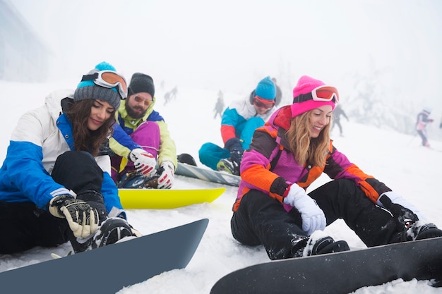 Dos parejas divirtiéndose y haciendo snowboard.