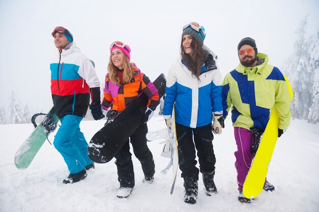 Dos parejas divirtiéndose y haciendo snowboard.