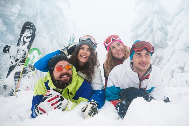 Dos parejas divirtiéndose y haciendo snowboard.